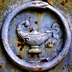 No explanation necessary. -well, that and Ive seen my cat do the same thing... gray ouroboros with lamp grave marker rust