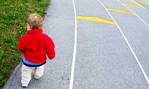 toddler with red jacket on starting line of racetrack